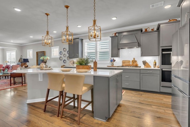 3002 Obion Pass, Spring Hill, TN 37174 - kitchen featuring gray cabinetry, ornamental molding, stainless steel appliances, light countertops, and custom exhaust hood