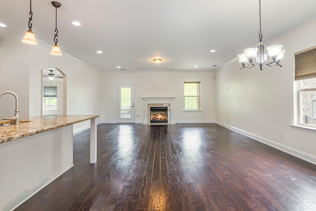 76 Molly Bright Ln, Franklin, TN 37064 - unfurnished living room with ornamental molding, dark wood finished floors, a fireplace with flush hearth, a chandelier, and recessed lighting