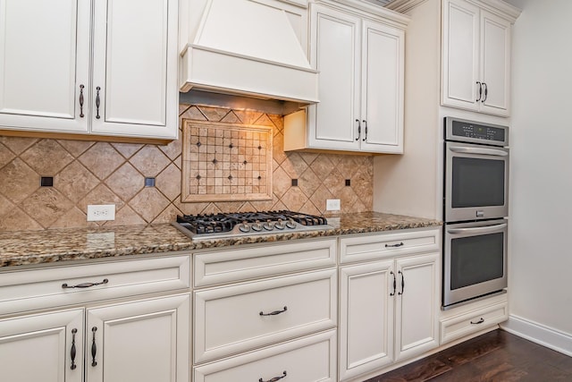 76 Molly Bright Ln, Franklin, TN 37064 - kitchen with appliances with stainless steel finishes, custom exhaust hood, light stone countertops, and decorative backsplash
