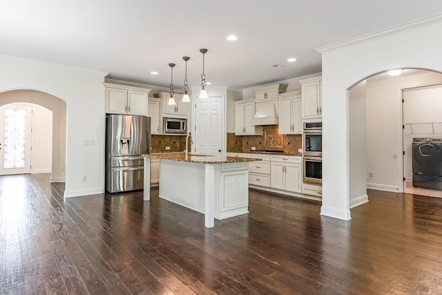 76 Molly Bright Ln, Franklin, TN 37064 - kitchen featuring stainless steel appliances, arched walkways, washer / clothes dryer, premium range hood, and crown molding