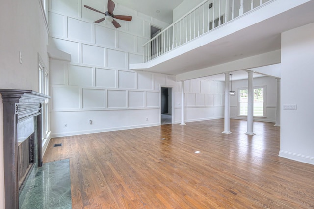 1202 Willow Brook Pass, Mount Juliet, TN 37122 - unfurnished living room featuring decorative columns, ceiling fan, a high end fireplace, a high ceiling, and wood finished floors