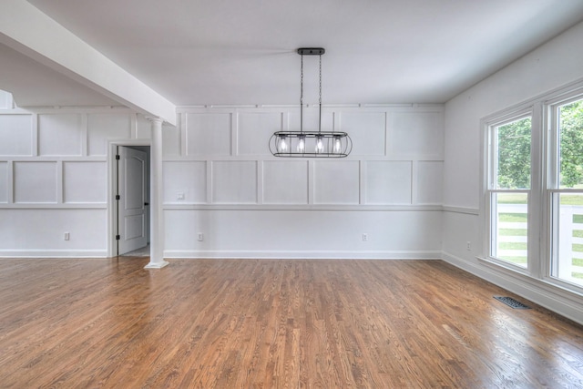 1202 Willow Brook Pass, Mount Juliet, TN 37122 - unfurnished dining area with wood finished floors, ornate columns, plenty of natural light, and a chandelier
