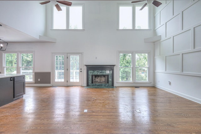 1202 Willow Brook Pass, Mount Juliet, TN 37122 - unfurnished living room featuring ceiling fan, a towering ceiling, a fireplace, healthy amount of natural light, and wood finished floors