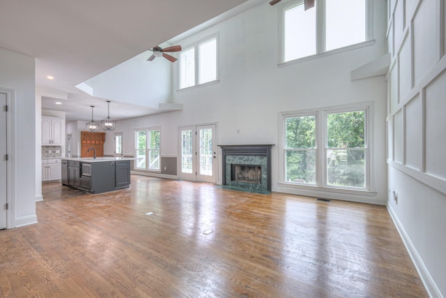 1202 Willow Brook Pass, Mount Juliet, TN 37122 - unfurnished living room with ceiling fan, a fireplace, a towering ceiling, light wood-type flooring, and recessed lighting
