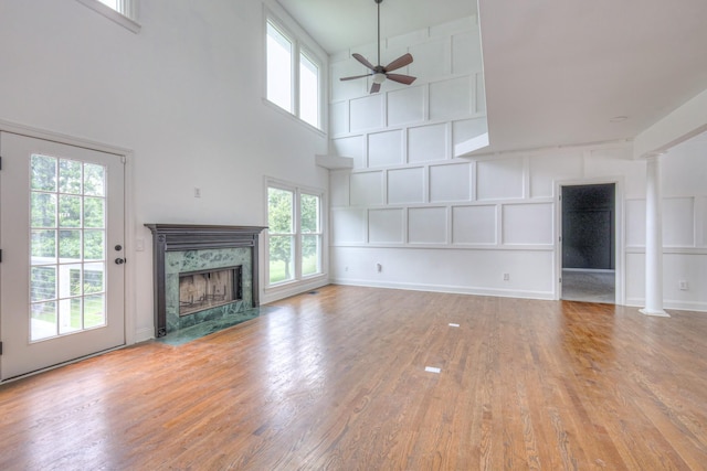 1202 Willow Brook Pass, Mount Juliet, TN 37122 - unfurnished living room featuring ceiling fan, a high end fireplace, decorative columns, wood finished floors, and a high ceiling