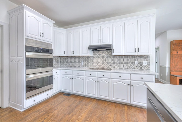 1202 Willow Brook Pass, Mount Juliet, TN 37122 - kitchen with stainless steel double oven, under cabinet range hood, white cabinets, and dark wood-type flooring
