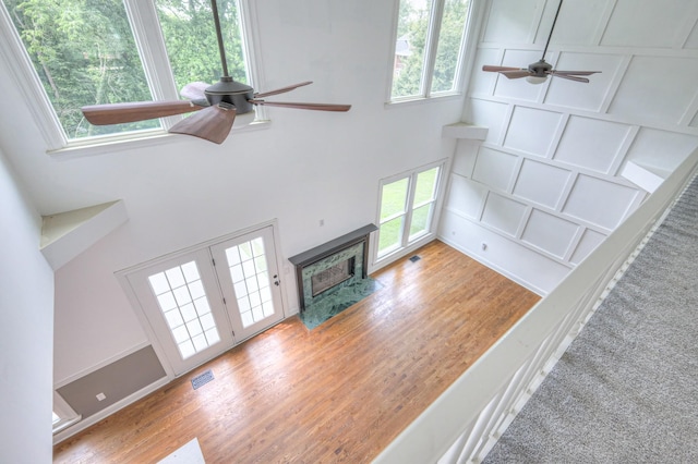1202 Willow Brook Pass, Mount Juliet, TN 37122 - unfurnished living room featuring a ceiling fan, a towering ceiling, light wood-style flooring, and a high end fireplace