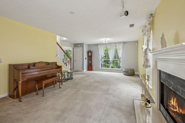 3524 Glenfalls Dr, Hermitage, TN 37076 - sitting room featuring a lit fireplace, carpet flooring, stairs, and a textured ceiling