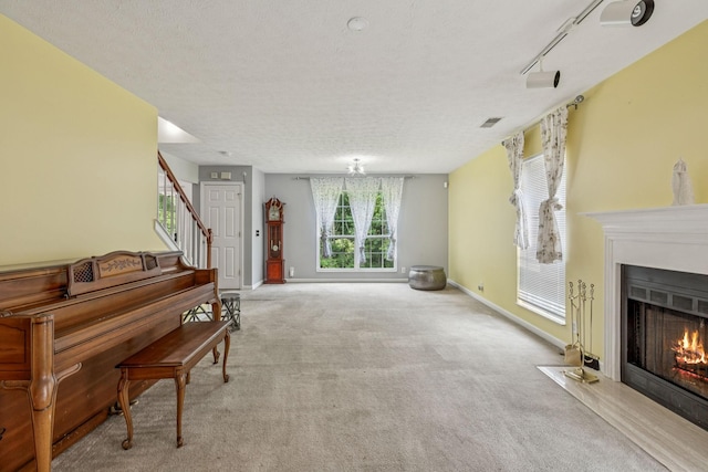3524 Glenfalls Dr, Hermitage, TN 37076 - living room with carpet, a fireplace with flush hearth, a textured ceiling, stairs, and rail lighting