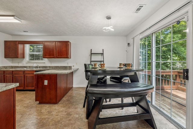 3524 Glenfalls Dr, Hermitage, TN 37076 - kitchen with a peninsula, a textured ceiling, plenty of natural light, hanging light fixtures, and light flooring