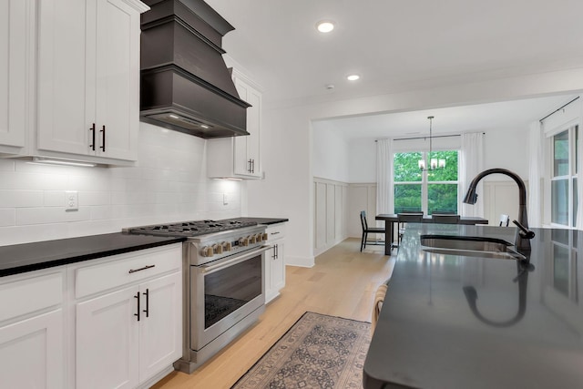 5509 Bridgemore Blvd, Murfreesboro, TN 37129 - kitchen featuring high end stainless steel range oven, custom range hood, dark countertops, light wood-style floors, and decorative backsplash