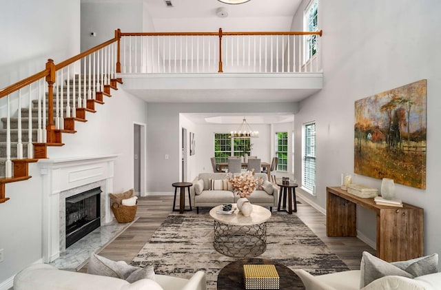77 Kendall Park Dr, Nashville, TN 37217 - living room with a high ceiling, a chandelier, wood finished floors, stairs, and a fireplace