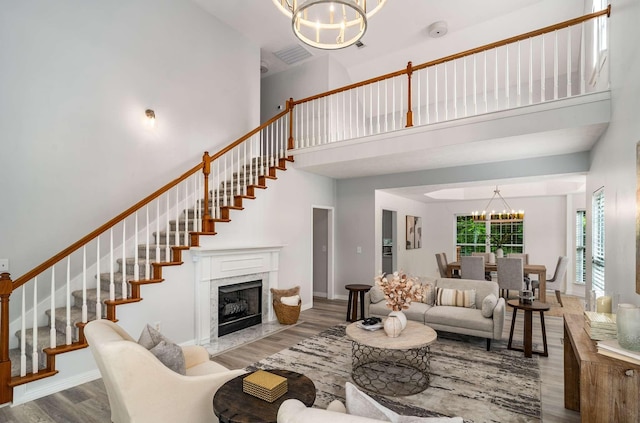 77 Kendall Park Dr, Nashville, TN 37217 - living area featuring a chandelier, wood finished floors, a high ceiling, stairs, and a premium fireplace