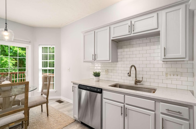 77 Kendall Park Dr, Nashville, TN 37217 - kitchen with dishwasher, decorative backsplash, light wood-style floors, decorative light fixtures, and light stone countertops