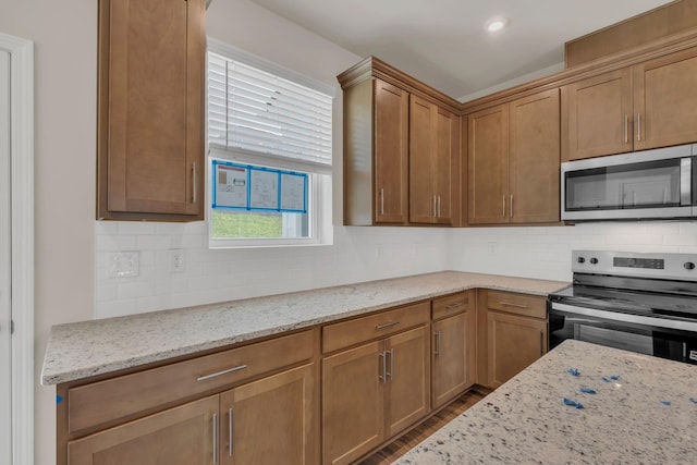 5211 Gladecress Ln, Hermitage, TN 37076 - kitchen featuring stainless steel appliances, wood finished floors, decorative backsplash, and light stone countertops