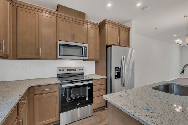 5211 Gladecress Ln, Hermitage, TN 37076 - kitchen featuring stainless steel appliances, light wood-type flooring, decorative backsplash, brown cabinets, and recessed lighting