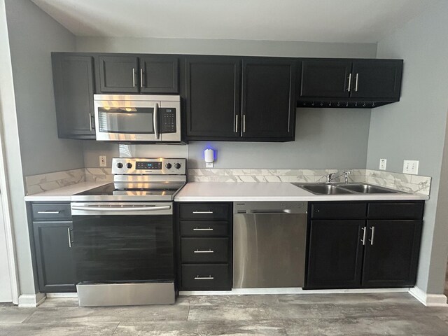 7206 Rosemary Ct, Fairview, TN 37062 - kitchen with stainless steel appliances, light countertops, light wood-type flooring, and dark cabinetry