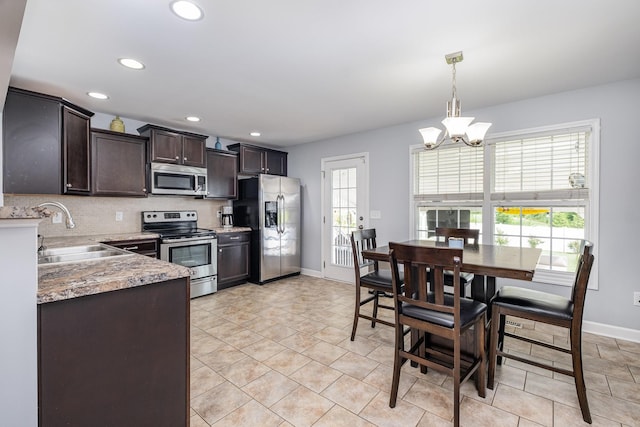 4611 Turquoise Ln, Murfreesboro, TN 37129 - kitchen with stainless steel appliances, dark brown cabinetry, a chandelier, decorative light fixtures, and recessed lighting