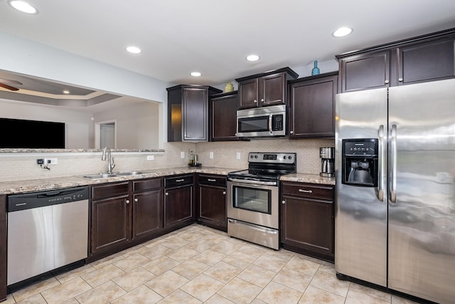 4611 Turquoise Ln, Murfreesboro, TN 37129 - kitchen with stainless steel appliances, backsplash, light stone countertops, dark brown cabinets, and light tile patterned floors