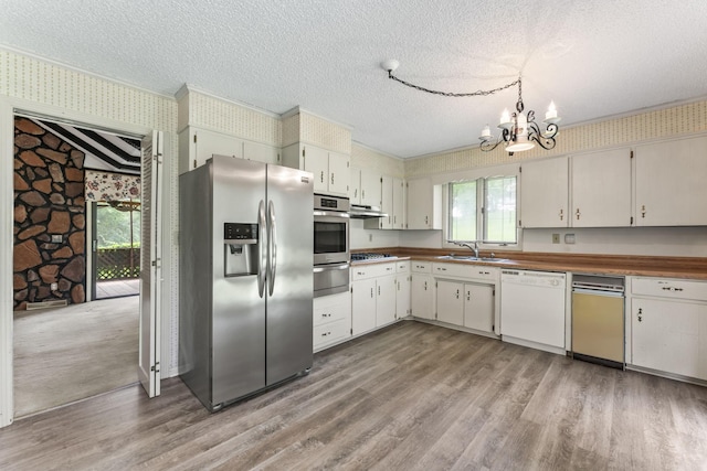 123 Proffitt St, Carthage, TN 37030 - kitchen featuring appliances with stainless steel finishes, a warming drawer, wallpapered walls, a textured ceiling, and a chandelier