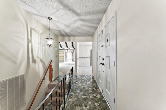 123 Proffitt St, Carthage, TN 37030 - hallway with a chandelier, a textured ceiling, and dark stone finish flooring