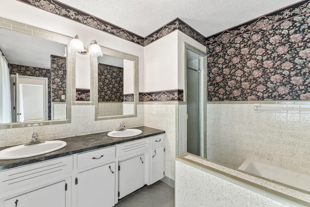 123 Proffitt St, Carthage, TN 37030 - bathroom featuring double vanity, wallpapered walls, tile patterned floors, a textured ceiling, and tile walls