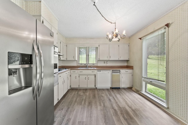 123 Proffitt St, Carthage, TN 37030 - kitchen with stainless steel appliances, wallpapered walls, light wood-style flooring, a chandelier, and a textured ceiling