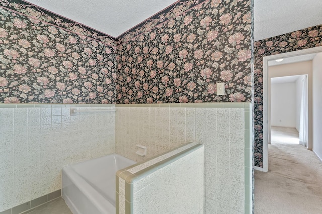 123 Proffitt St, Carthage, TN 37030 - full bathroom featuring wallpapered walls, wainscoting, a textured ceiling, a bath, and tile walls