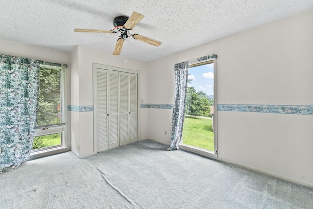 123 Proffitt St, Carthage, TN 37030 - unfurnished bedroom with multiple windows, carpet flooring, a closet, a textured ceiling, and ceiling fan