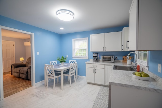 502 N Main St, Loretto, TN 38469 - kitchen featuring light countertops, white cabinets, light wood-style flooring, and recessed lighting
