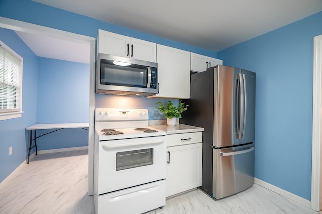 502 N Main St, Loretto, TN 38469 - kitchen with stainless steel appliances, white cabinets, light countertops, and light wood-style floors