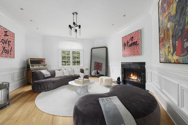2410 Hidden River Ln, Franklin, TN 37069 - living area featuring light wood-type flooring, a lit fireplace, ornamental molding, a decorative wall, and a wainscoted wall
