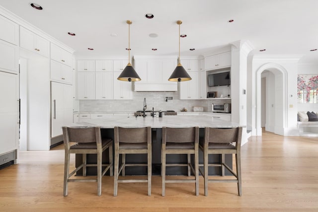 2410 Hidden River Ln, Franklin, TN 37069 - kitchen with white cabinetry, decorative backsplash, light wood finished floors, and crown molding