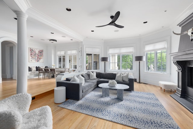 2410 Hidden River Ln, Franklin, TN 37069 - living room with ornamental molding, arched walkways, ceiling fan, decorative columns, and a fireplace with raised hearth