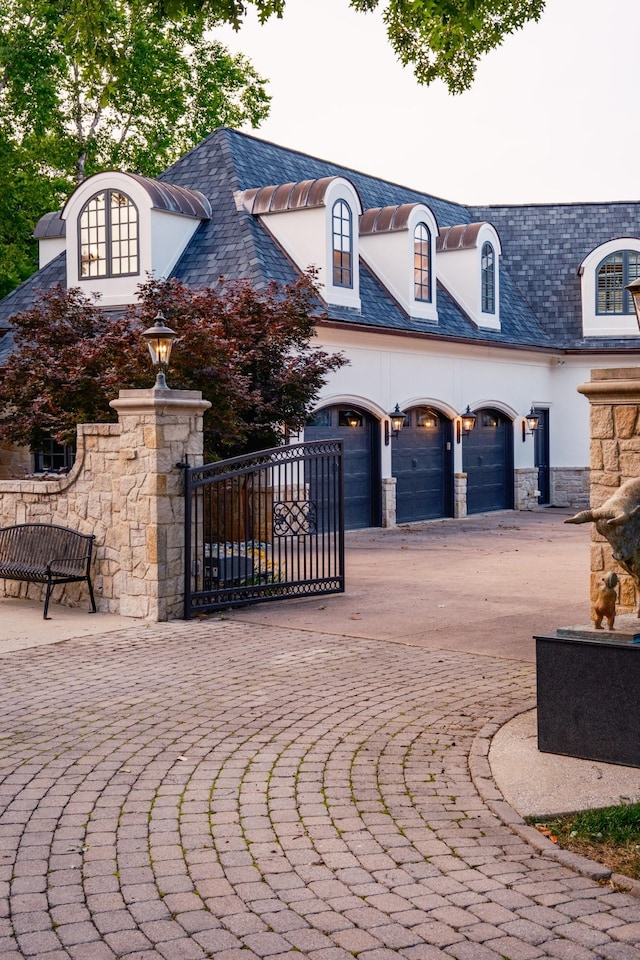 2410 Hidden River Ln, Franklin, TN 37069 - french provincial home with stone siding, a high end roof, a gate, an attached garage, and stucco siding