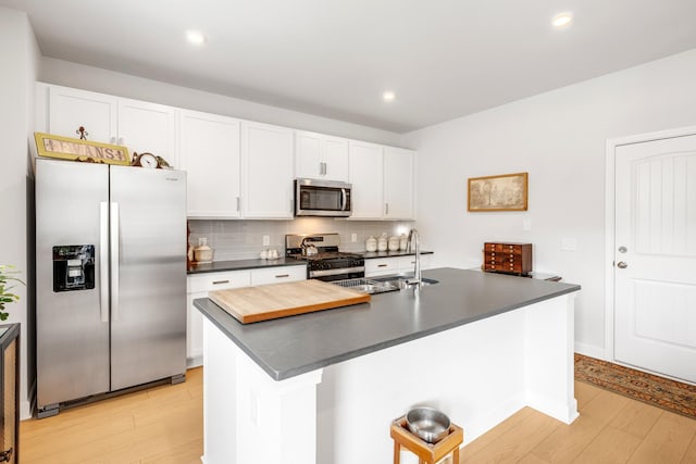 127 Millbrook Dr, Spring Hill, TN 37174 - kitchen with appliances with stainless steel finishes, dark countertops, light wood-type flooring, backsplash, and recessed lighting