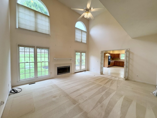 416 Barnes Dr, Lebanon, TN 37087 - unfurnished living room featuring light carpet, high vaulted ceiling, plenty of natural light, a ceiling fan, and a glass covered fireplace