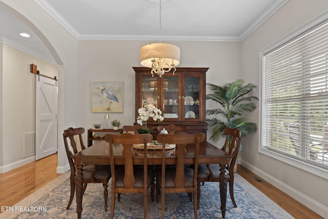 48 Riverside Dr, Oak Ridge, TN 37830 - dining room with arched walkways, light wood-style flooring, ornamental molding, and a barn door