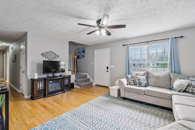 113 Beck Ct, Murfreesboro, TN 37128 - living room featuring light wood-style floors, a ceiling fan, stairs, and a textured ceiling