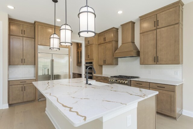 5959 Hunt Valley Dr, Spring Hill, TN 37174 - kitchen featuring custom exhaust hood, decorative backsplash, light stone counters, a kitchen island with sink, and recessed lighting