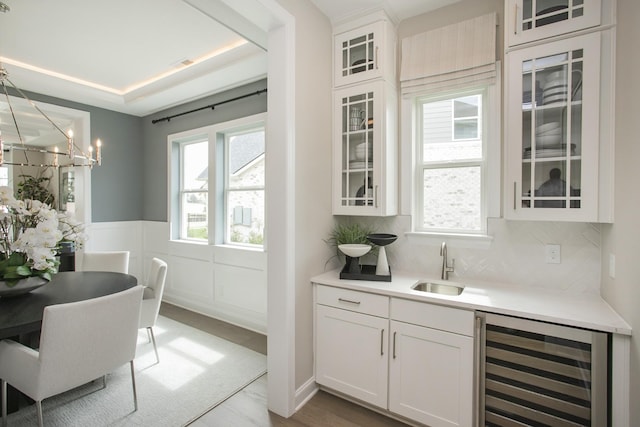 5969 Hunt Valley Dr, Spring Hill, TN 37174 - indoor wet bar featuring beverage cooler, plenty of natural light, a wainscoted wall, a chandelier, and backsplash