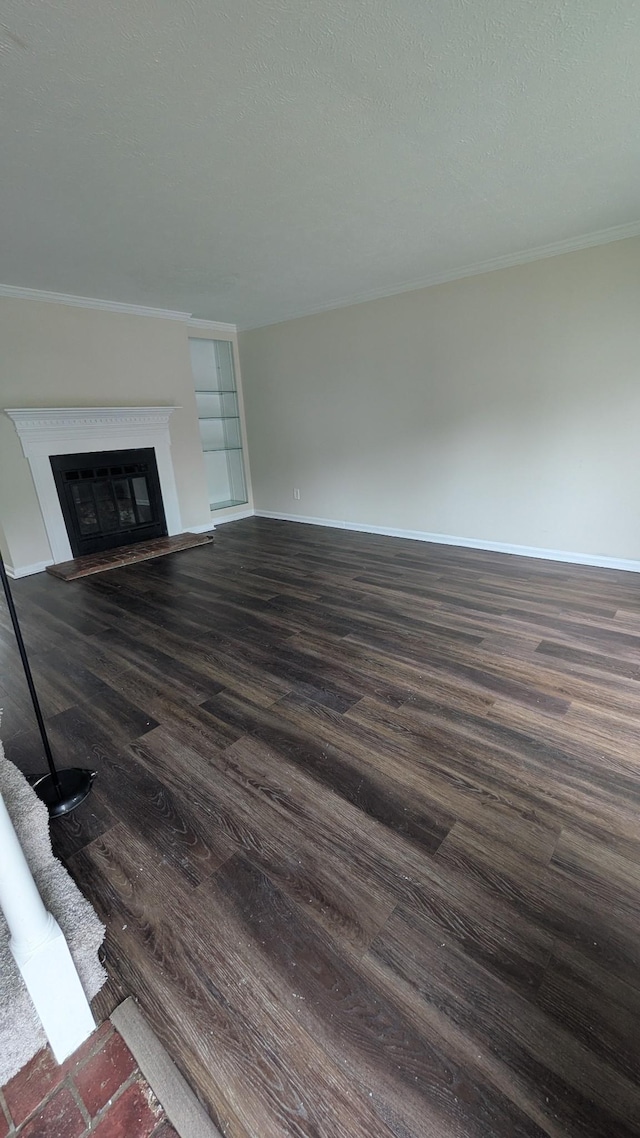 106 Beech Forge Dr, Antioch, TN 37013 - unfurnished living room featuring dark wood finished floors, a glass covered fireplace, and crown molding