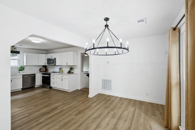 3345 Towneship Rd, Antioch, TN 37013 - kitchen featuring stainless steel appliances, white cabinetry, a chandelier, wood finished floors, and light countertops