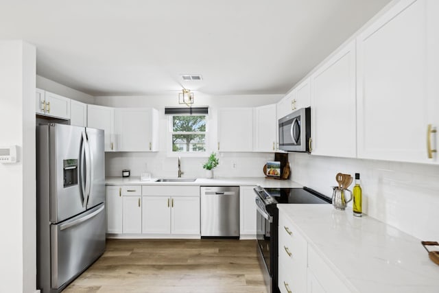 3345 Towneship Rd, Antioch, TN 37013 - kitchen featuring appliances with stainless steel finishes, white cabinets, backsplash, and light wood-style flooring