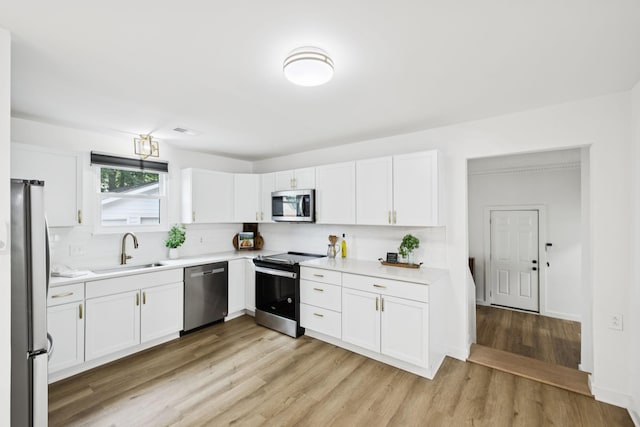 3345 Towneship Rd, Antioch, TN 37013 - kitchen with appliances with stainless steel finishes, light countertops, white cabinetry, and light wood finished floors