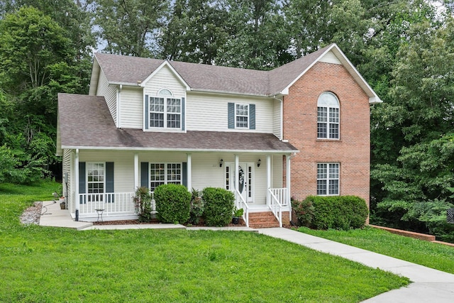 237 Windsor Dr, Cookeville, TN 38506 - traditional home featuring covered porch, a front lawn, a shingled roof, brick siding, and view of scattered trees