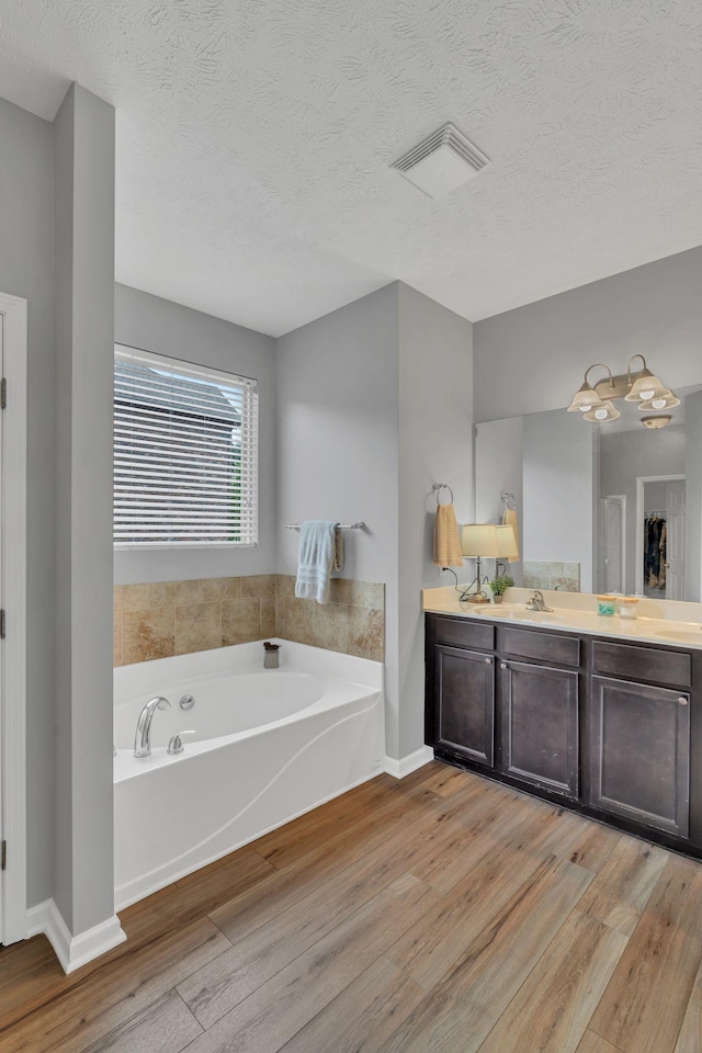 147 N Shadowhaven Way, Hendersonville, TN 37075 - full bathroom featuring wood finished floors, a bath, vanity, a textured ceiling, and a chandelier