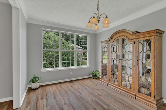 147 N Shadowhaven Way, Hendersonville, TN 37075 - unfurnished dining area with a chandelier, wood finished floors, ornamental molding, and a textured ceiling