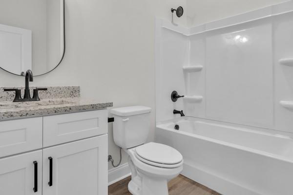 179 Charleston Ave, Pleasant View, TN 37146 - full bathroom featuring wood finished floors, vanity, and shower / tub combination