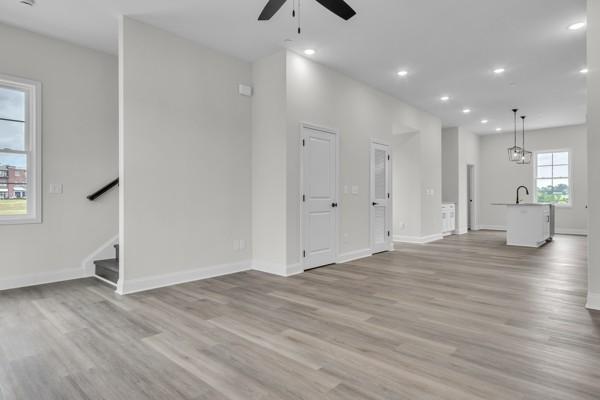 179 Charleston Ave, Pleasant View, TN 37146 - unfurnished living room featuring a ceiling fan, light wood finished floors, recessed lighting, and stairway